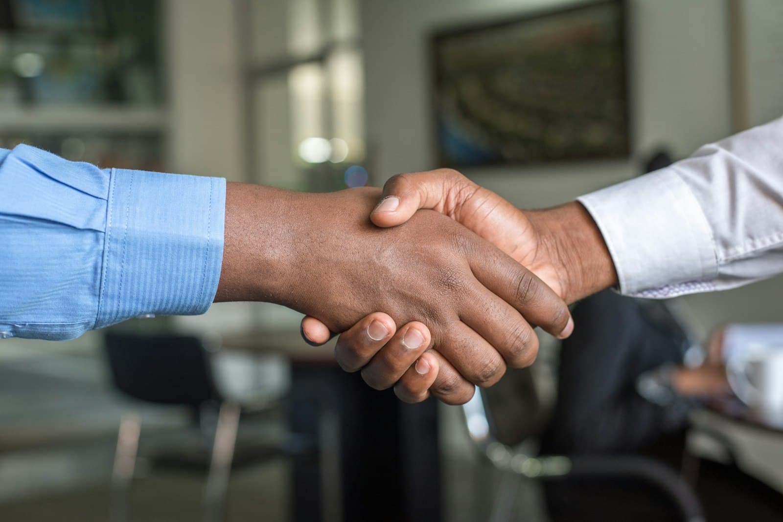 Two people shaking hands across a desk