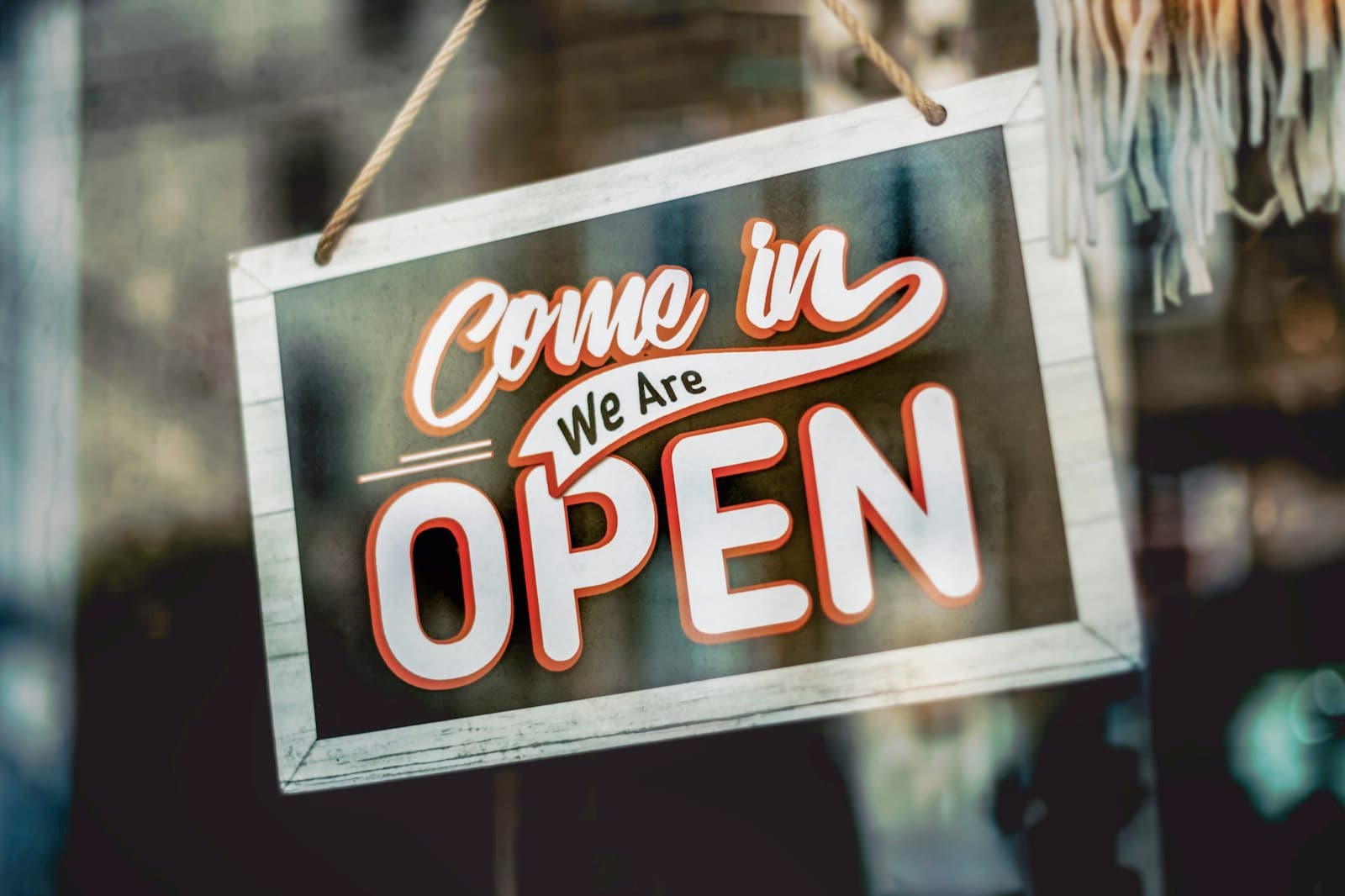 “Come in, we are open” sign hanging in a new shop's window