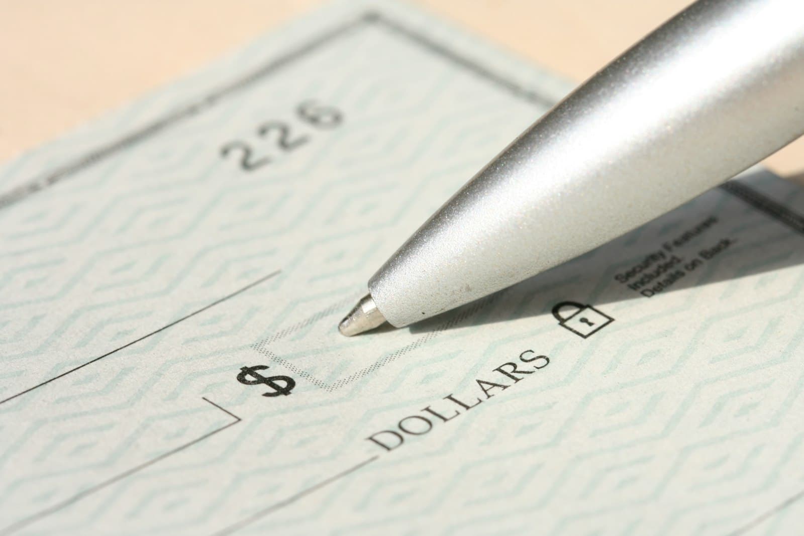Pen poised over a paycheck