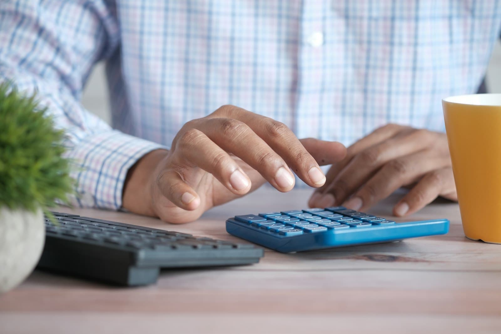 Business owner working through figures on a calculator at a desk