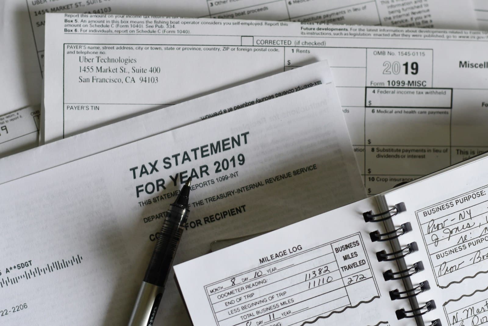Tax statement and 1099 forms with a pen on a desk