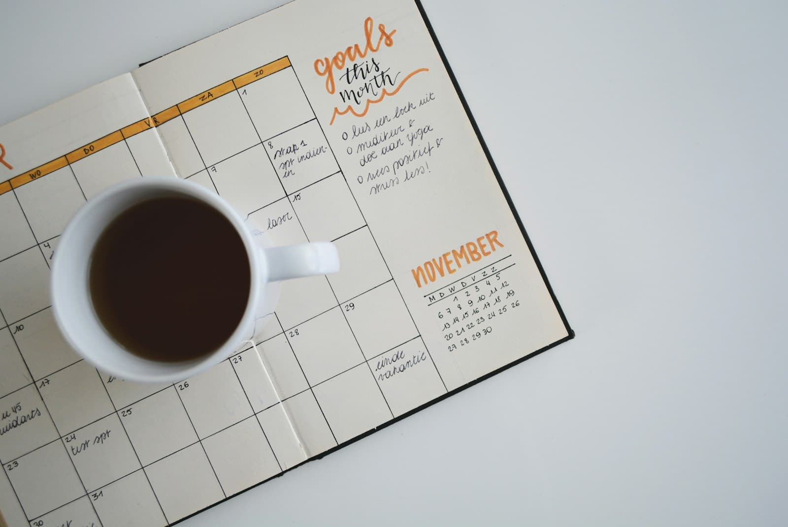 Monthly planner open beside a cup of coffee